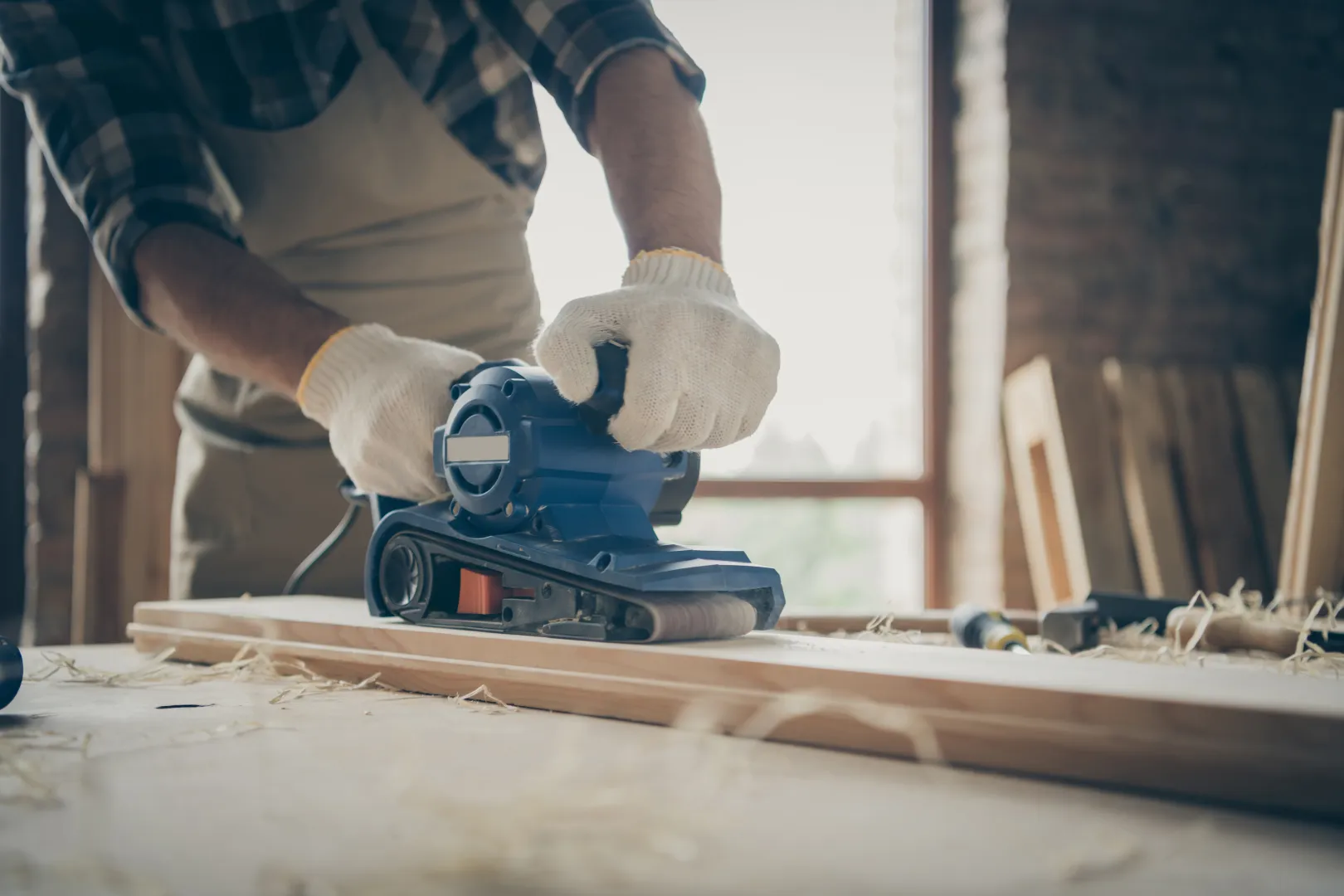 cropped-close-up-man-travaillant-avec-du-papier-de-verre-entoure-de-depots-de-traitement-de-bloc-de-bois-avec-les-mains-dans-les-gants cropped-close-up-man-travaillant-avec-du-papier-de-verre-entoure-de-depots-de-traitement-de-bloc-de-bois-avec-les-mains-dans-les-gants